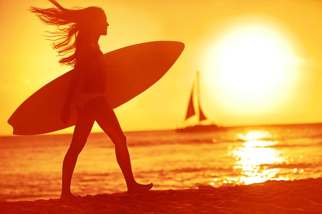 Surfing surfer woman babe beach fun at sunset. Girl walking in s